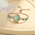 Close-up of rose gold clover bracelet watch with green dial and gemstone leaf links. - Clover Stretch Bracelet Watch (Green Dial) / Green