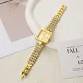 Primer plano de un elegante reloj cuadrado para mujer en oro con pulsera de cadena de strass - Dorado