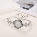 Detail view of silver women's bracelet watch with flower charms and rhinestones - Silver
