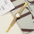 Elegant gold women's watch with rhinestone details on a lifestyle background - Gold