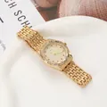 Detailed view of luxury gold quartz watch featuring red diamond accents and crystal-set dial - Gold Women's