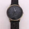Detailed macro view of bronze quartz watch featuring a black denim textured dial - Gray