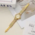 Detailed close-up of an elegant gold ladies watch with full rhinestone pavé dial and bracelet - Gold