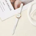 Detail view of a white leather strap watch with a geometric octagonal rose gold case. - White