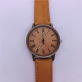 Close-up van een vintage bronzen kwartshorloge met gele band in denim textuur. - Geel