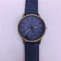 Gedetailleerde weergave van een denim quartzhorloge met een vintage bronzen kast. - Blauw