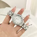 Macro view of silver luxury watch with rhinestone bezel and adjustable steel band details - White