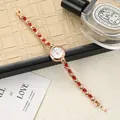 Close-up detail of luxury rose gold women's watch featuring red rhinestone bracelet - Rose Gold Red