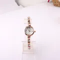 Elegant rose gold women's bracelet watch featuring crystal accents and heart links - White