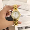 Close-up of gold rhinestone quartz watch dial and metal link bracelet. - Gold