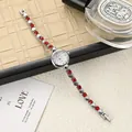 Macro shot of a silver heart-shaped bracelet watch with red crystals on a luxury setting - White and Red
