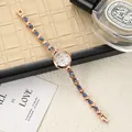 Elegant rose gold bracelet watch featuring blue crystals and heart-shaped links detail - Rose Gold Blue