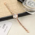 Close-up of an elegant rose gold women's bracelet watch with sparkling rhinestone details - Rose Gold White