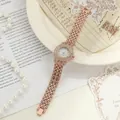 Detailed view of a rose gold quartz watch encrusted with shimmering rhinestones. - Rose Gold