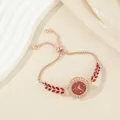 Elegant rose gold women's bracelet watch with red leaf accents and sparkling rhinestones - Red