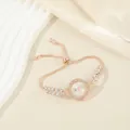 Elegant rose gold bracelet watch with rhinestone leaf accents and adjustable chain. - White
