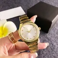 Gold-toned luxury women's watch with rhinestone bezel and white dial on model's hand - Gold