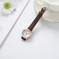 Gros plan d'une montre femme minimaliste avec bracelet en cuir marron et boîtier en or rose - Bracelet Café Cadran Blanc