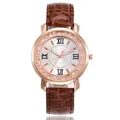 Close-up view of a rose gold quartz watch with rhinestones and brown leather strap - Coffee