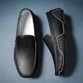 Detailaufnahme von schwarzen Leder-Loafern mit weißen Nähten und grauem Wellenbesatz - 38 / Schwarz