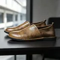 Detailopname van vintage bruine leren instappers met handgemaakte stiksels aan de zijkant - 38 / Bruin (11668)