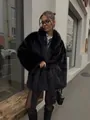Detaillierte Streetstyle-Aufnahme eines schwarzen Kunstpelzmantels mit Revers und Gürtel - XS / Oberteile / Schwarz