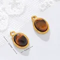 Detailed macro view of tiger eye stone pendant with dimensions of 12.7mm x 8.2mm - Oval Shape / Approx. 1.3g/pc