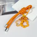 Detalle del llavero de cuerda de cuero naranja DIY con colgantes de estrella naranja. - Nudo peruano / Naranja