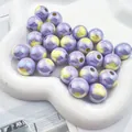 Detailed macro of iridescent purple and yellow heart print acrylic beads for DIY crafting - Purple