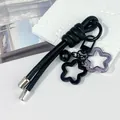 Detailed view of creative DIY leather rope keychain featuring star charms and a black bell - Peruvian Knot / Black