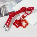 Detalle del llavero de cuerda de cuero rojo anudado con campana y colgantes de estrellas - Doble nudo / Rojo