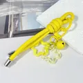 Detalle del creativo llavero de cordón de cuero amarillo con campana y estrellas - Nudo peruano / Amarillo