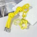 Detalle de llavero DIY de cordón de cuero amarillo con colgantes de flores y cascabel - Doble nudo / Amarillo