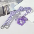 Primer plano de un llavero de cuero morado anudado con cascabel y colgantes de estrella - Doble nudo / Púrpura