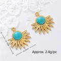 Macro detail view of two 18K gold plated sunburst charms with turquoise stone. - Needle-Like Fan