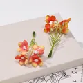Vista macro dettagliata di due fiori di seta artificiale con petali arancio e giallo. - 5 pezzi/confezione / arancio-rosso