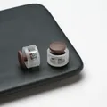 Détail macro de serre-cordons en plastique translucide et marron sur une surface noire. - Boucle de Réglage à Ressort Double Trou / Lot de 10 / Café Semi-transparent