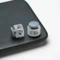 Close-up of translucent plastic cord locks with grey toggle buttons and springs - Double Hole Spring Adjustment Buckle / 10 Pieces Pack / Semi-transparent Gray
