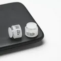 Detailed view of translucent white double-hole plastic spring cord locks with internal springs - Double Hole Spring Adjustment Buckle / 10 Pieces Pack / Translucent