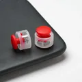 Detailed close-up view of two red round plastic cord locks with transparent body and spring - Double Hole Spring Adjustment Buckle / 10 Pieces Pack / Semi-transparent Red