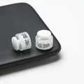Macro close-up view of white plastic double-hole spring cord locks for drawstring adjustment - Double Hole Spring Adjustment Buckle / 10 Pieces Pack / Semi-transparent White