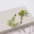 Primo piano dettagliato di piccoli fiori di seta artificiale per accessori per capelli fai da te - 5 Pezzi/Confezione / Verde chiaro