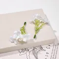 Primo piano di piccoli fiori di seta artificiale per accessori per capelli fai-da-te - 5 Pezzi/Confezione / Bianco
