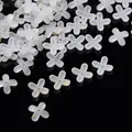 Macro detail of frosted white acrylic four-petal flower beads with gold foil accents. - Gold Foil Four-Petal Flower Cap / 100 Pieces/Pack / White