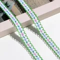 Detailaufnahme von zarter floral bestickter Spitzenborte mit grünem Wellenrand - 1m / Grün