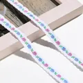 Detaillierte Nahaufnahme von weißem Spitzenband mit blauen und rosa bestickten Blumen - 1m / Weiß Blau Rosa