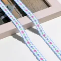 Nahaufnahme von Blumenbestickte Borte mit gewellten blauen Kanten und kleinen rosa Blüten - 1m / Himmelblau Rosa