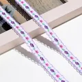 Makro-Detail von floral besticktem Webband mit lila Wellenrand für DIY-Projekte - 1m / Hellviolett