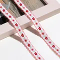 Nahaufnahme von Blumenstickband mit zarten, gewellten Bogenkanten für Dekoration - 1m / Pink pink