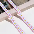 Detailansicht der bestickten Blumenspitze mit rosa Wellenrand und bunten Blüten. - 1m / Dunkelrosa